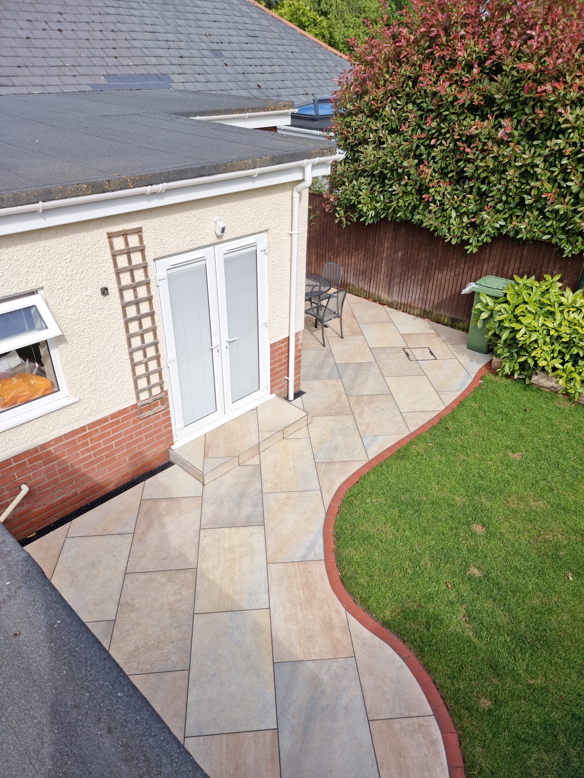 Riven sandstone patio and curved path with brick edging, laid by Greenwave