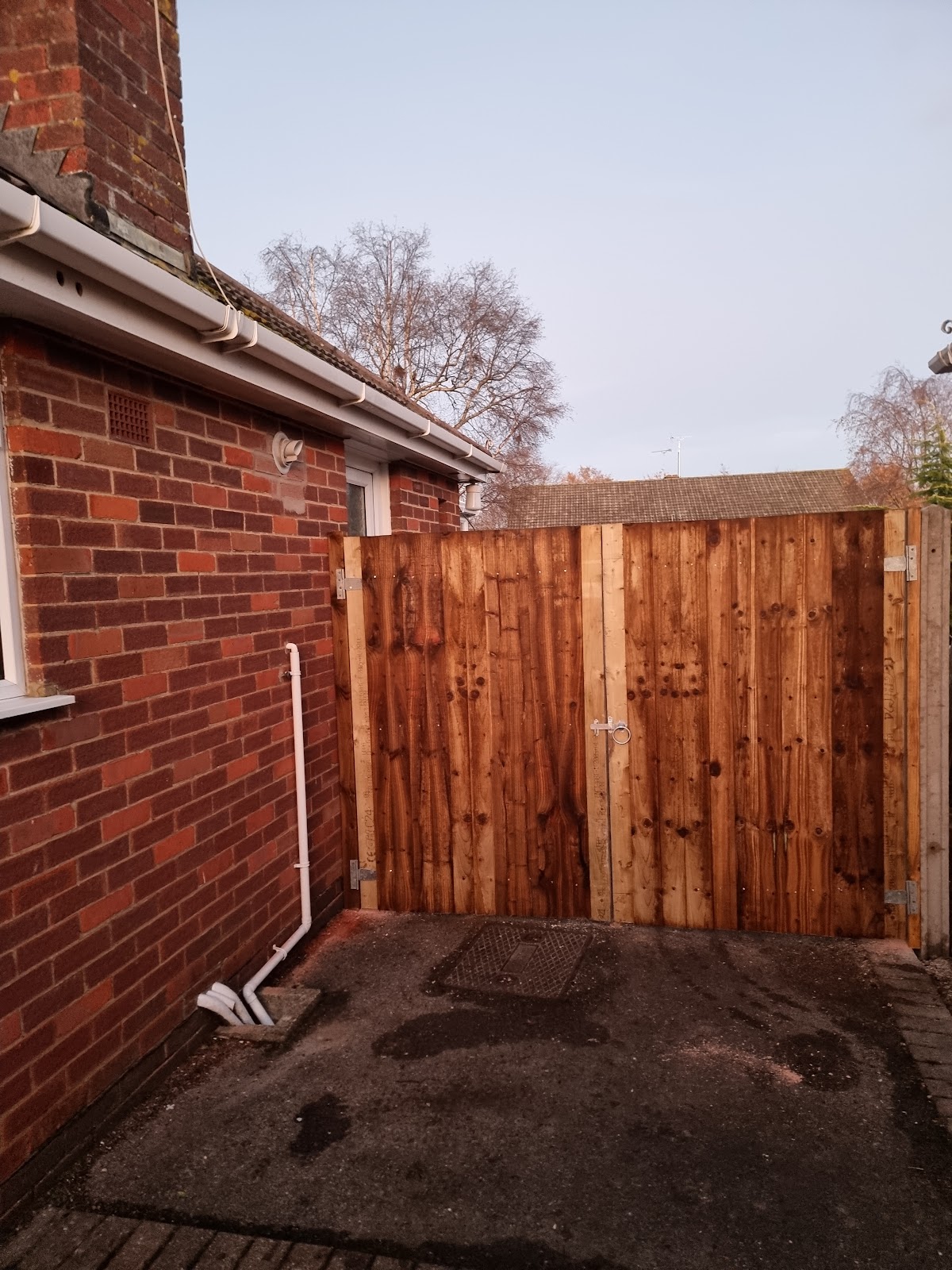 New feather edge timber gates and fence panels beside a tarmac drive
