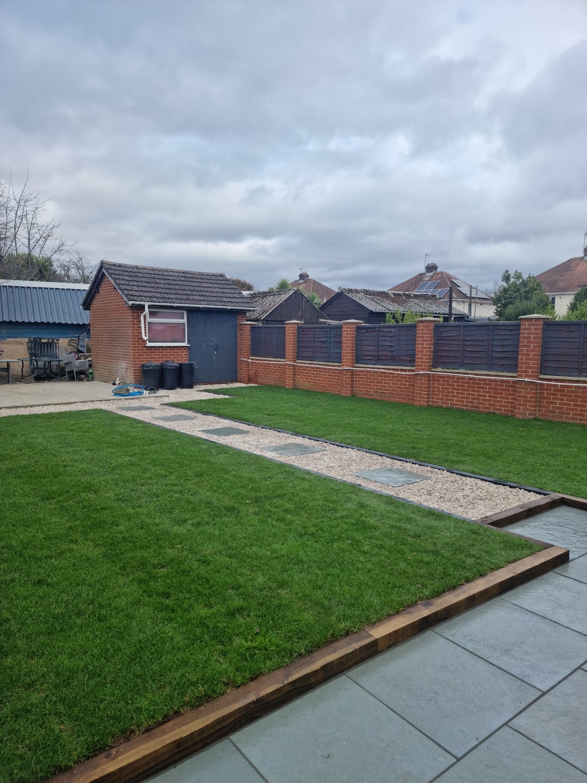 New lawn with gravel and stepping stone path edged in timber sleepers