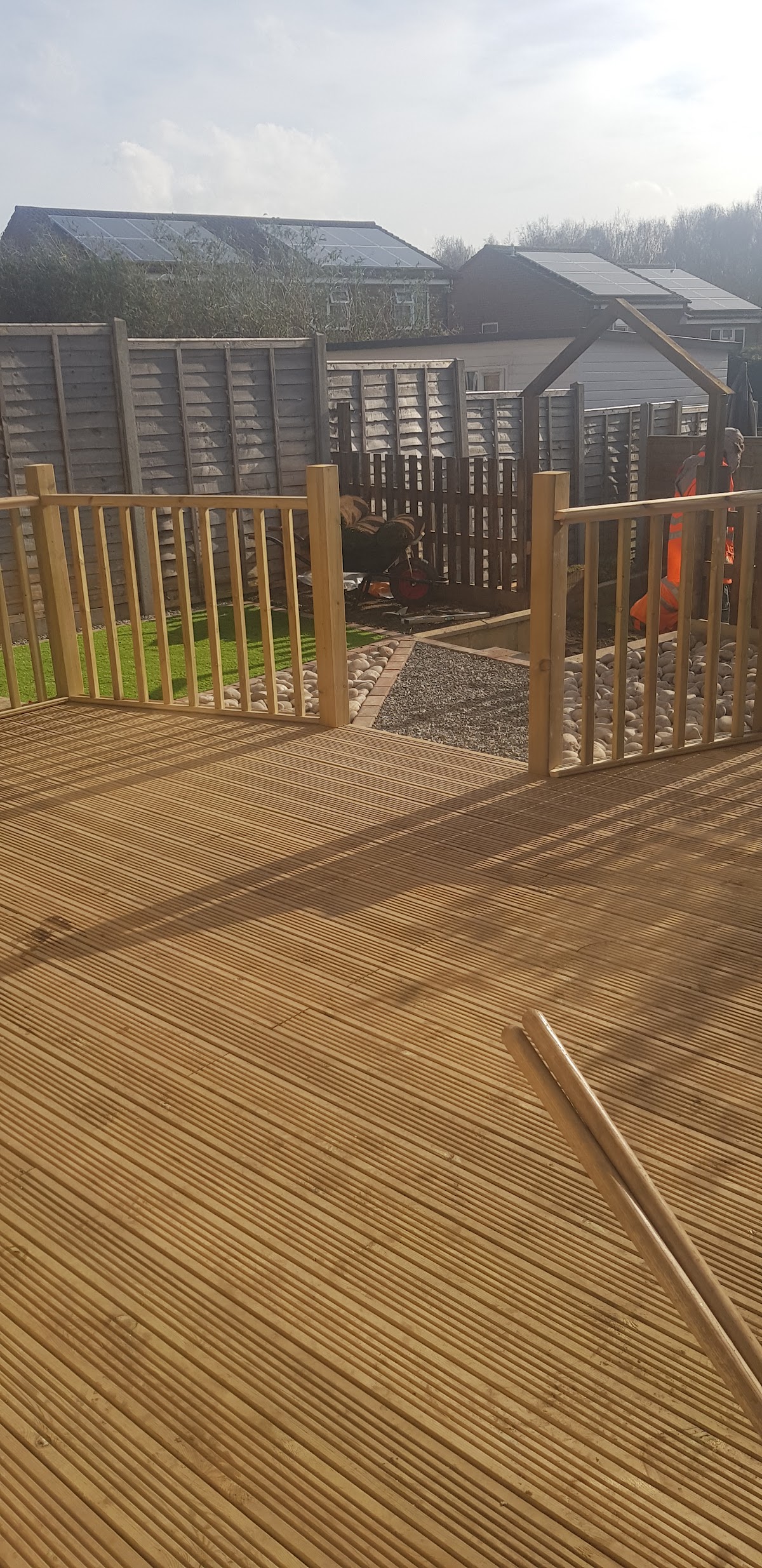 New timber decking with railings alongside gravel and lawn